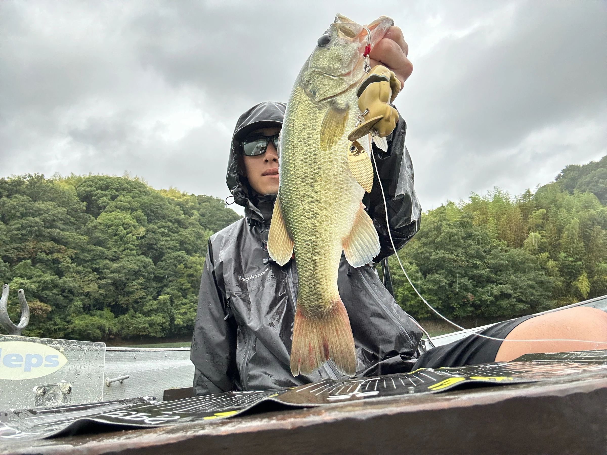 Angler holding a black bass caught on Billiken Lure