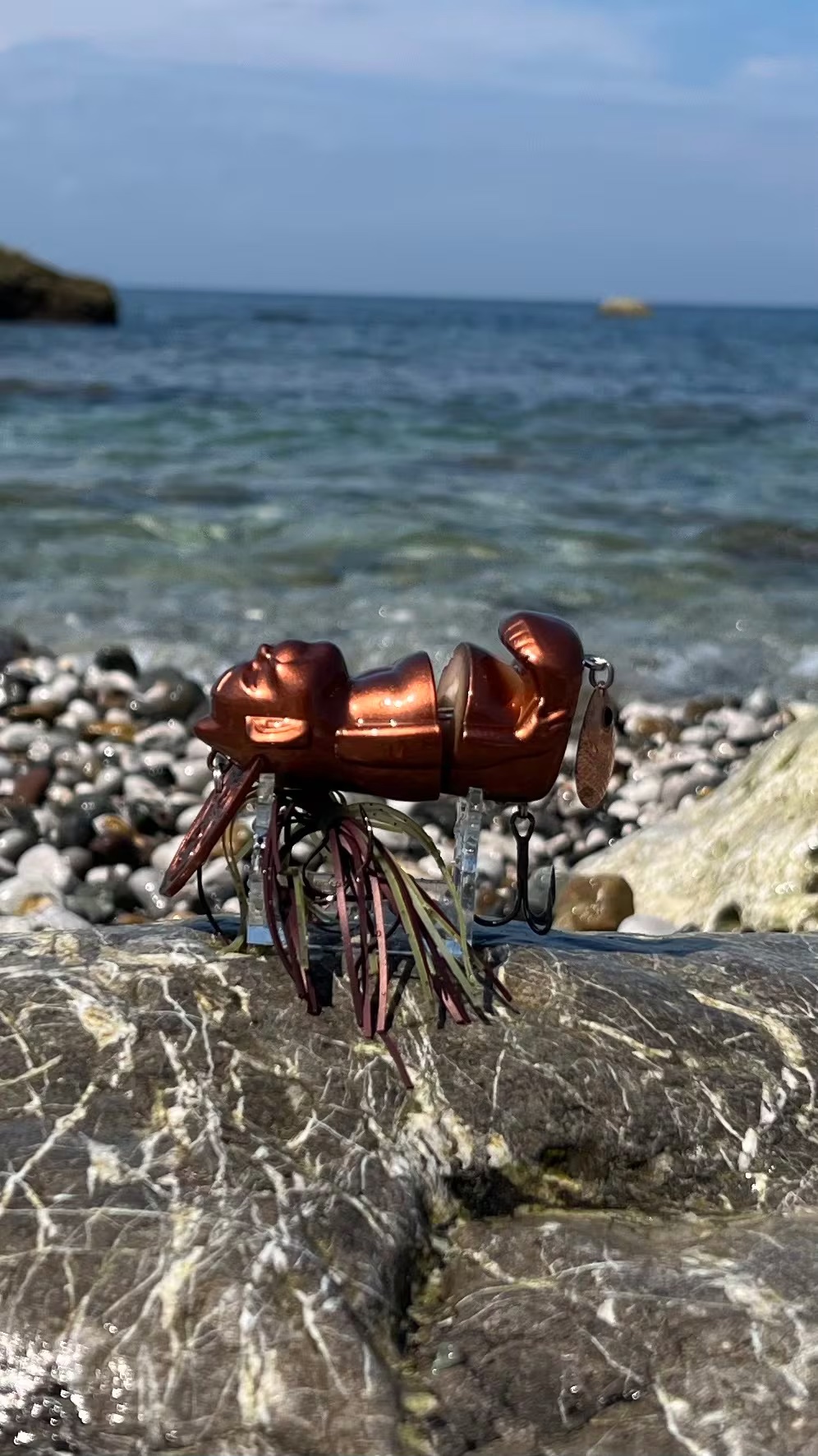 Bronze Billiken Lure fitted with a silicone skirt and Colorado blade
