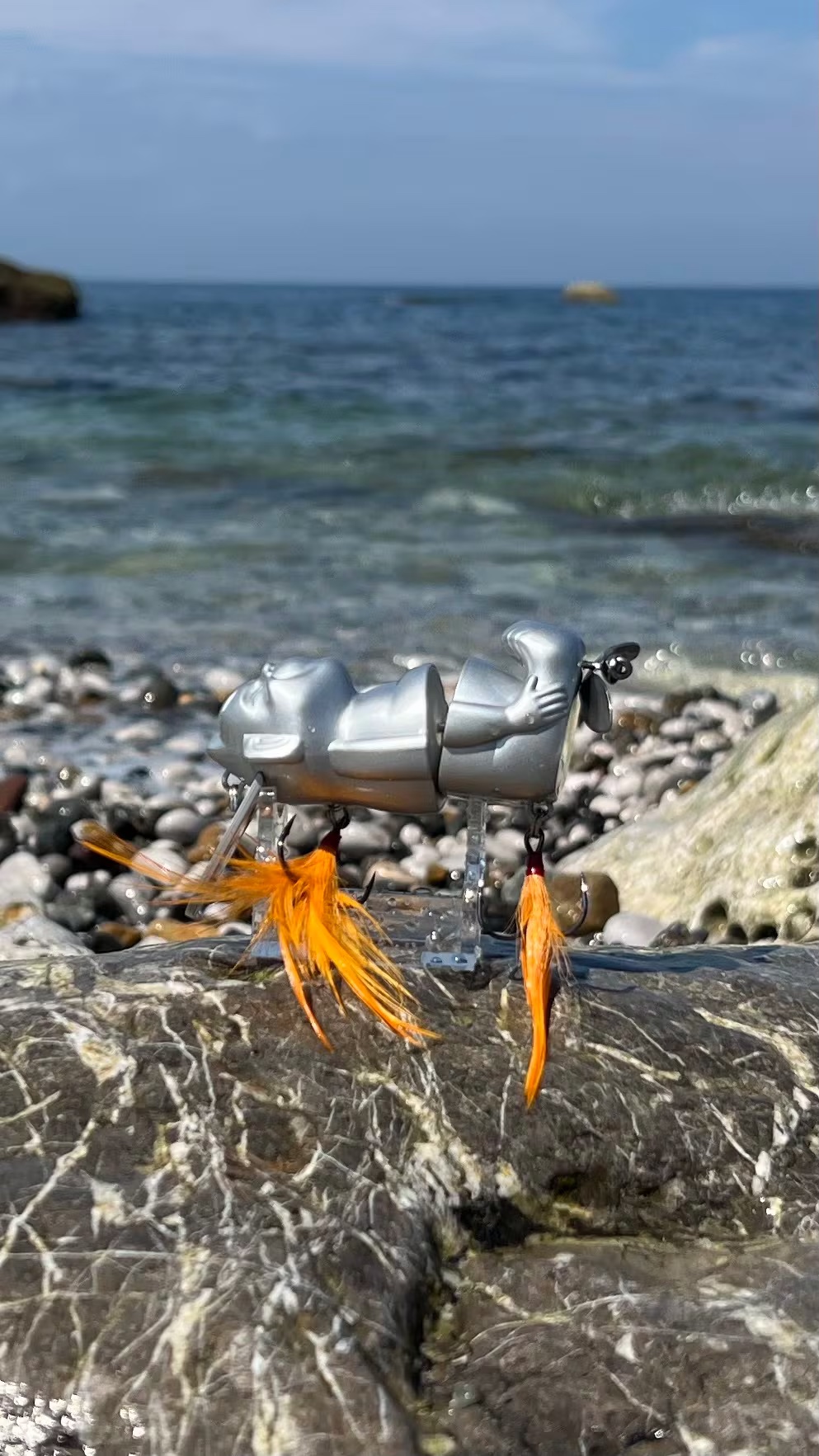 Silver Billiken Lure fitted with a feather hook and original prop